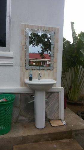 a bathroom with a sink and a mirror at Rock Shadow Hotel in Koboko