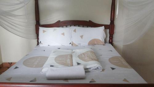 ein Bett mit Handtüchern und Kissen darauf in der Unterkunft Rock Shadow Hotel in Koboko