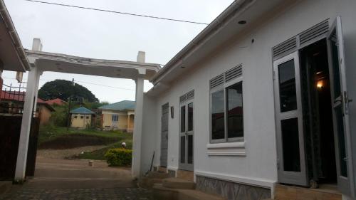 a white house with an open door at Rock Shadow Hotel in Koboko
