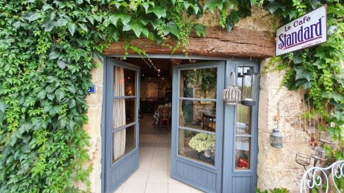 un restaurante con una puerta azul y hiedra en Le Clos Goëlle en Moissat