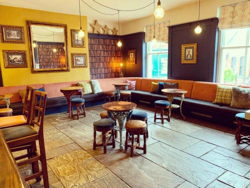 a bar with a couch and tables and chairs at The Royal Oak Ripon in Ripon