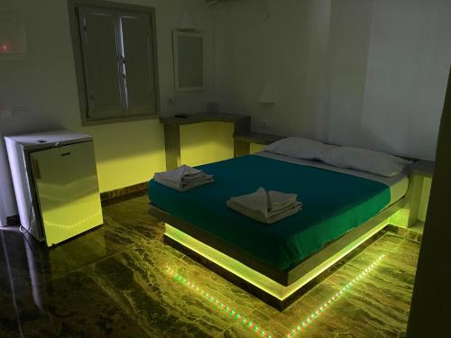 a bedroom with a bed with lights on the floor at Hotel Hellas in Fira