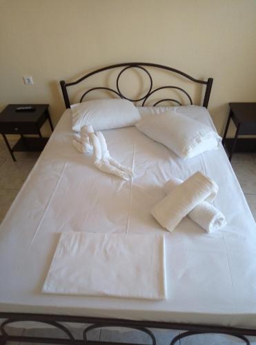 a white bed with two white pillows and a stuffed animal on it at House Lena in Sarti