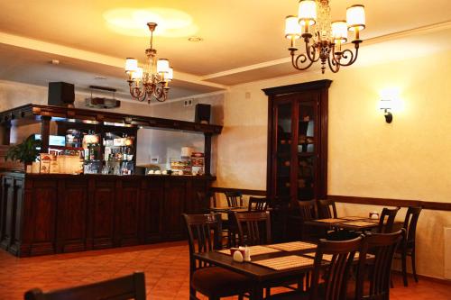 a restaurant with tables and chairs and a bar at Classic Hotel in Pyatigorsk