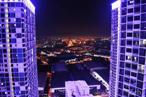 a view of two tall buildings at night at i-City-Casa Joy - Wifi, Netflix - Movies, Parking, Sleeps 7 Pax in Kampong Padang Jawa