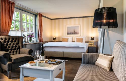 una camera d'albergo con letto, divano e tavolo di Hotel Reethüüs a Kampen