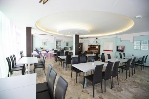 una sala da pranzo con tavoli e sedie di Hotel Mirage a Bellaria-Igea Marina