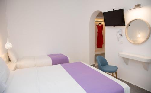 a bedroom with a bed and a sink and a mirror at Markakis Studios Fira Town in Fira