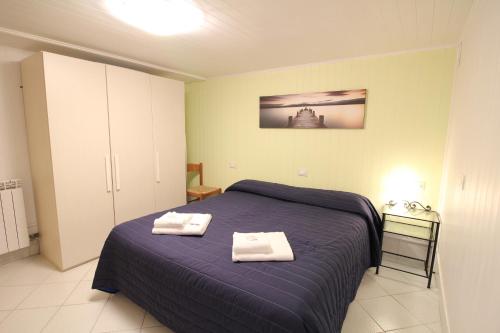 sypialnia z niebieskim łóżkiem i 2 ręcznikami w obiekcie Veneziacentopercento Picenin Apartment w Wenecji