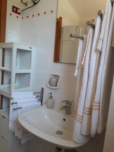 Baño blanco con lavabo y espejo en Chia Zeffiro, en Chia