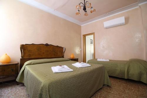 um quarto com 2 camas e lençóis verdes em Veneziacentopercento Arsenale Apartment em Veneza