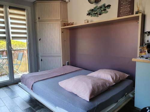 een bed met twee kussens in een kamer bij Studio accès direct à la plage in La Londe-les-Maures