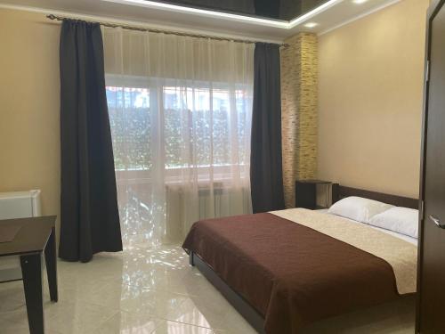 a bedroom with a bed and a large window at Міні-готель "Кімната Комфорт" in Odesa