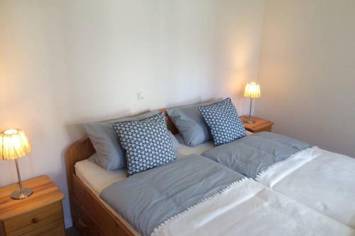 a bed with blue pillows on it in a bedroom at Pension Bach in Greifswald