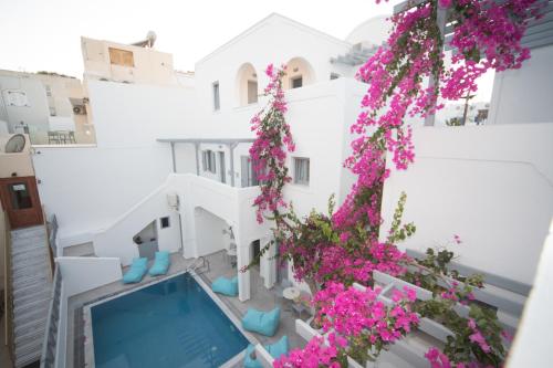 a view from the balcony of a house with pink flowers at Markakis Studios Fira Town in Fira
