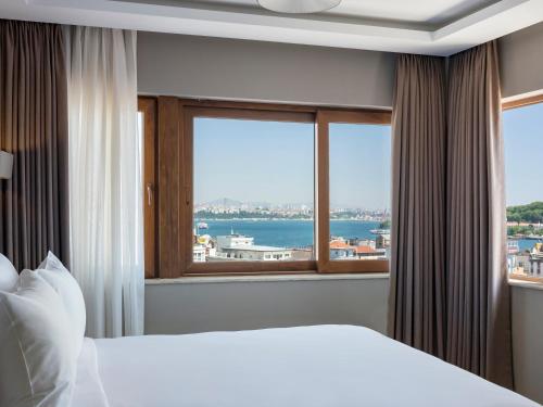 a bedroom with a bed and a large window at Azzap Hotel Galata in Istanbul