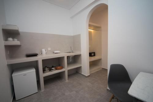 a kitchen with a sink and a table with a chair at Markakis Studios Fira Town in Fira