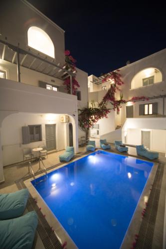a large blue swimming pool in front of a building at Markakis Studios Fira Town in Fira