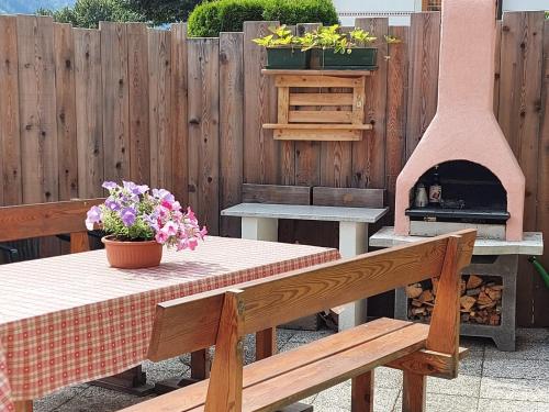 a picnic table with a pizza oven in a backyard at Casa Danoli in Canale San Bovo