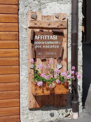 a sign on the side of a building with flowers at Casa Danoli in Canale San Bovo