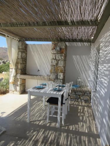 una mesa blanca y sillas en un patio en Villa Handras, 2 unità, en Egíali