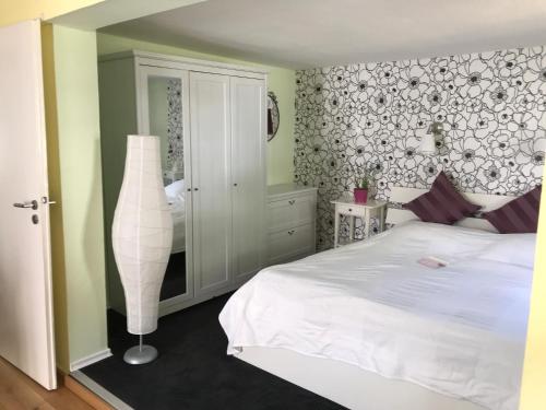 a bedroom with a white bed and a lamp at Schräges Haus in Treis-Karden