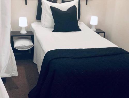 a bedroom with a large white bed with two lamps at Folwark Nadmorska Ostoja in Mechelinki