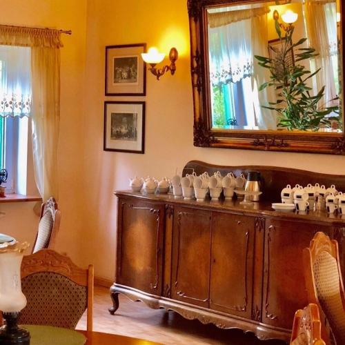 a room with a large wooden cabinet with cups on it at Folwark Nadmorska Ostoja in Mechelinki