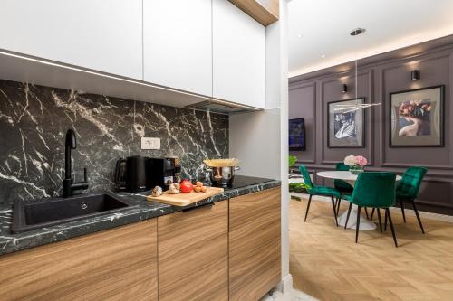 a kitchen with a sink and a table with green chairs at Luxury Number 1 Apartments in Rijeka