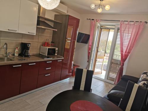a kitchen and dining room with a table and chairs at Apartmani Andrea in Kraljevica