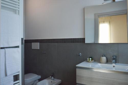 a bathroom with a sink and a toilet and a mirror at La Silvana B&B in Coriano