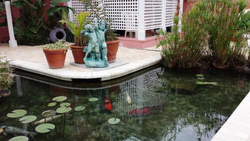 a koi pond with a statue in a garden at Windemere Inn by the Sea in Melbourne