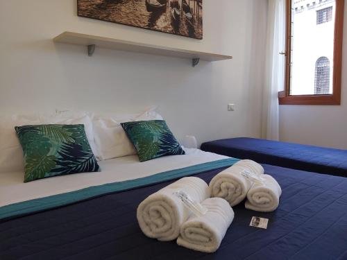 ein Schlafzimmer mit einem Bett mit Handtüchern darauf in der Unterkunft Veneziacentopercento Corderie Apartment in Venedig