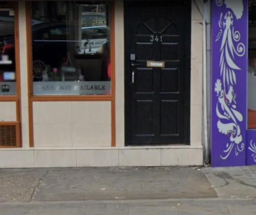 a black door on the side of a store at Lord Merit Guest Rooms in King's Cross St Pancras in London