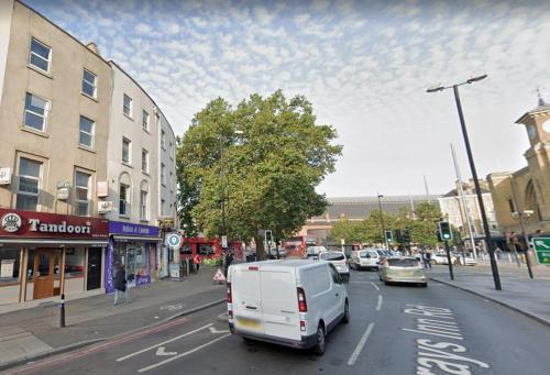 a white van is driving down a city street at Lord Merit Guest Rooms in King's Cross St Pancras in London