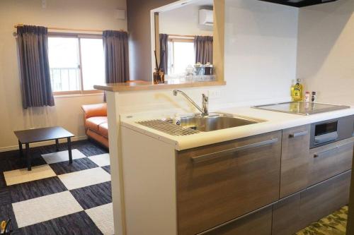 Harbour Inn & Suites 201 في نيغاتا: مطبخ مع حوض و كونتر توب