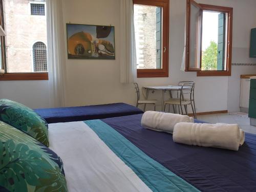 a room with a bed with two pillows on it at Veneziacentopercento Corderie Apartment in Venice