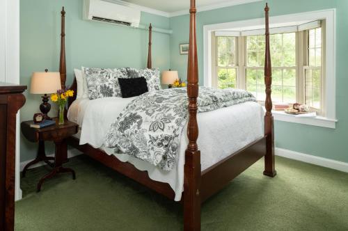 a bedroom with a bed with a white comforter at 1802 House Bed & Breakfast in Kennebunkport