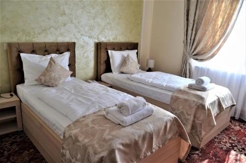 ein Schlafzimmer mit 2 Betten und Handtüchern darauf in der Unterkunft Pensiunea Romeo Resort in Focşani