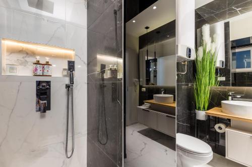 a bathroom with a shower and a toilet and a sink at Luxury Number 1 Apartments in Rijeka
