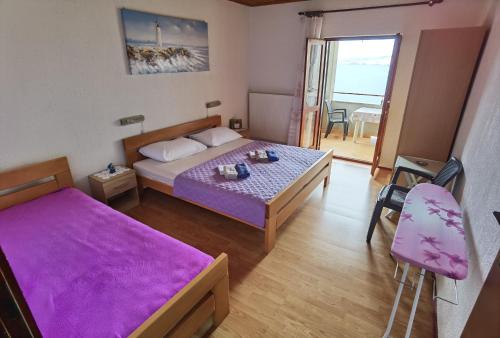 1 dormitorio con cama y mesa con sábanas moradas en Apartments NONO, en Senj