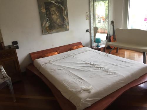 a bedroom with a bed with white sheets at Casa delle sorprese in Pescara
