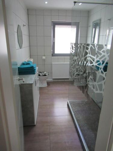 a bathroom with a sink and a toilet and a window at WeCo Ferienwohnungen in Zirndorf