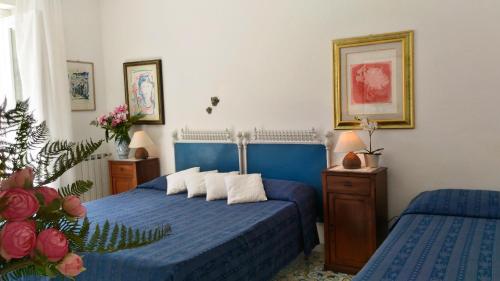 a bedroom with two beds with blue sheets at Villa Vista Mare Mela in Lipari