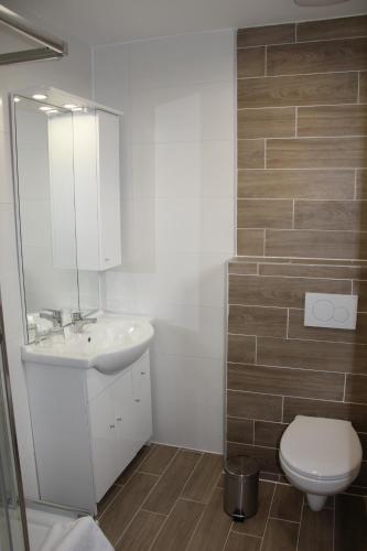 ein Badezimmer mit einem weißen Waschbecken und einem WC in der Unterkunft Harangtorony Szálló in Kőszeg