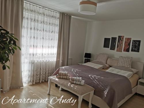 a bedroom with a bed and a table and a window at Apartment Andy in Medvode