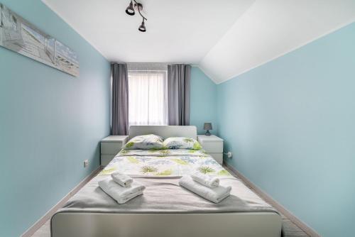 a bedroom with a bed with towels on it at Apartamenty Mewa in Rewa
