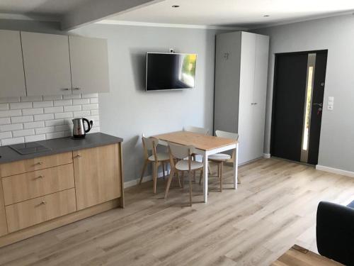 a kitchen and dining room with a table and chairs at Apartamenty i Domki WyDmy Międzywodzie in Międzywodzie