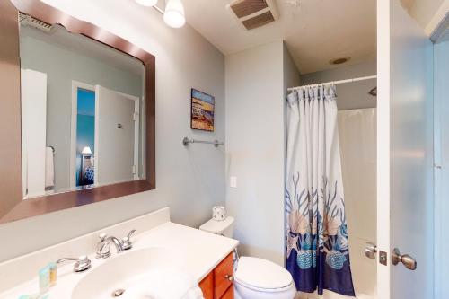 a bathroom with a sink and a toilet and a mirror at Seascape 218 in Isle of Palms