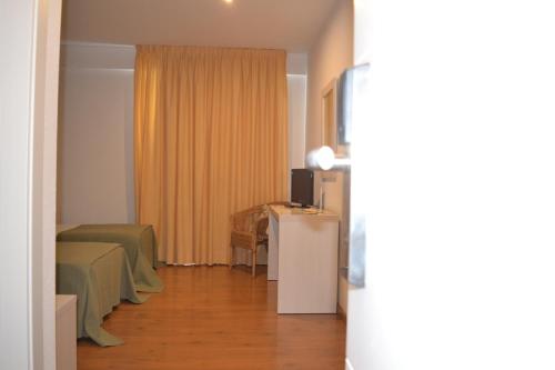 a hotel room with two beds and a television at Duerming Villa De Sarria Hotel in Sarria